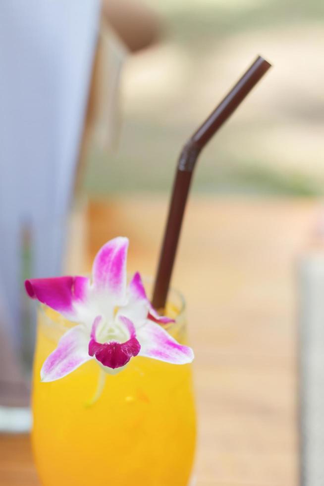 close-up de um coquetel de laranja com uma flor foto