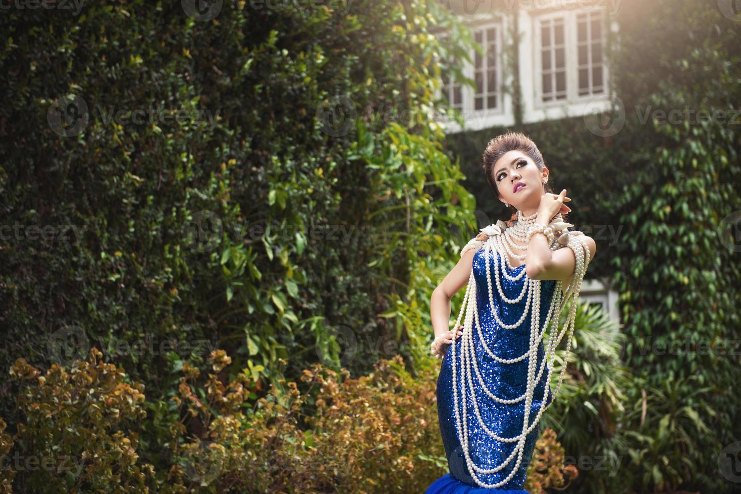 bela dama de vestido azul de luxo com pérola foto