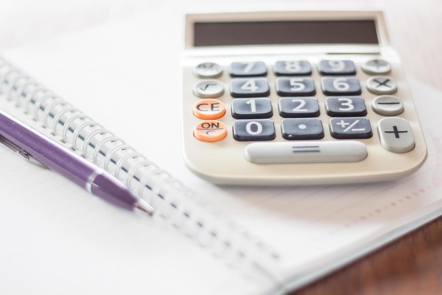 calculadora e uma caneta em um notebook foto