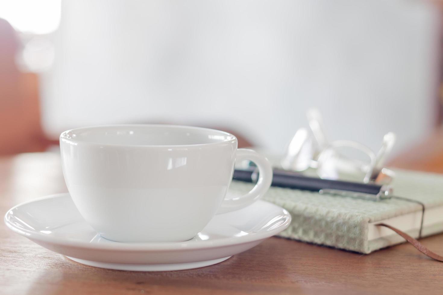 close-up de uma xícara de café branca em uma mesa de madeira foto