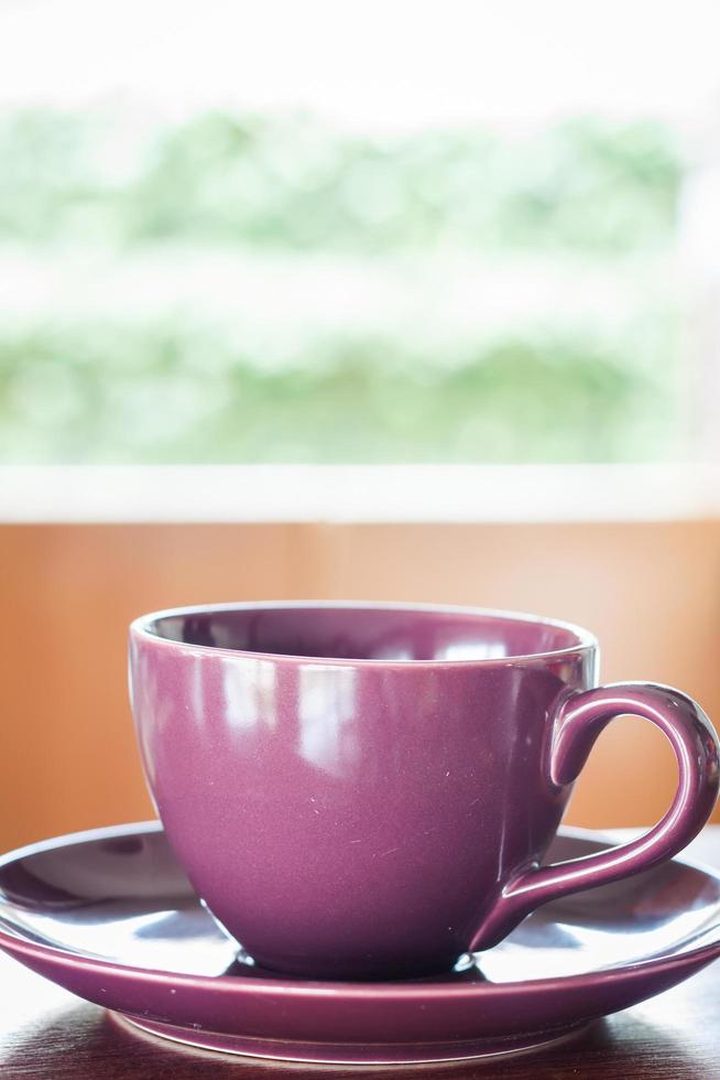 xícara de café roxa perto de uma janela foto
