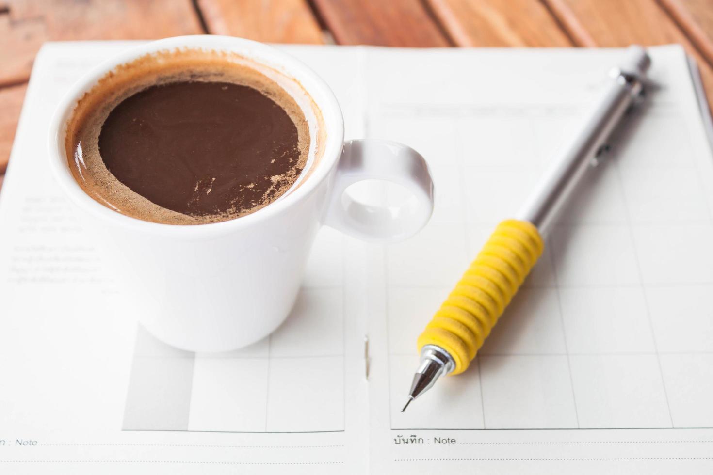 xícara de café expresso branco em um notebook foto