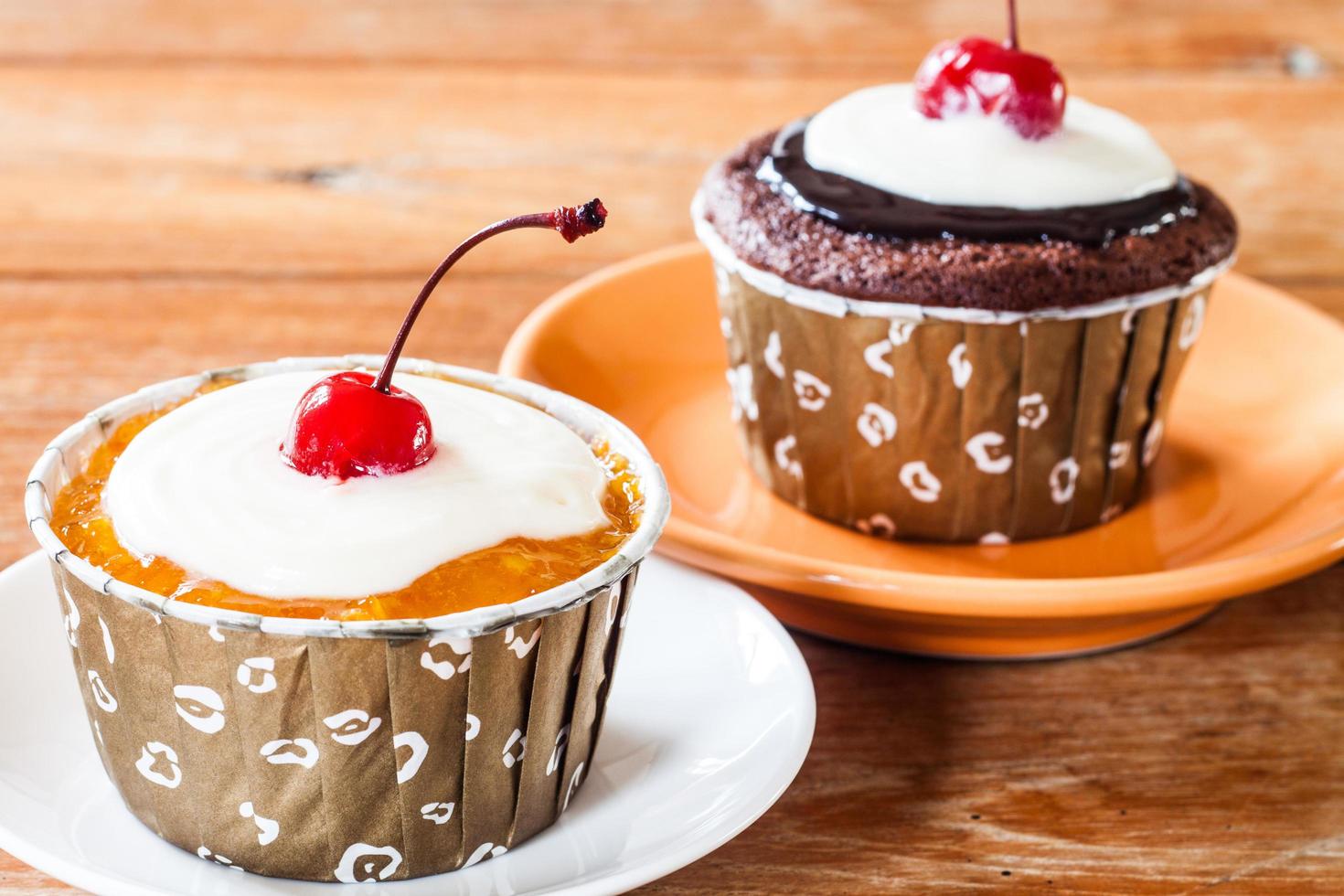 dois cupcakes em uma mesa de madeira foto