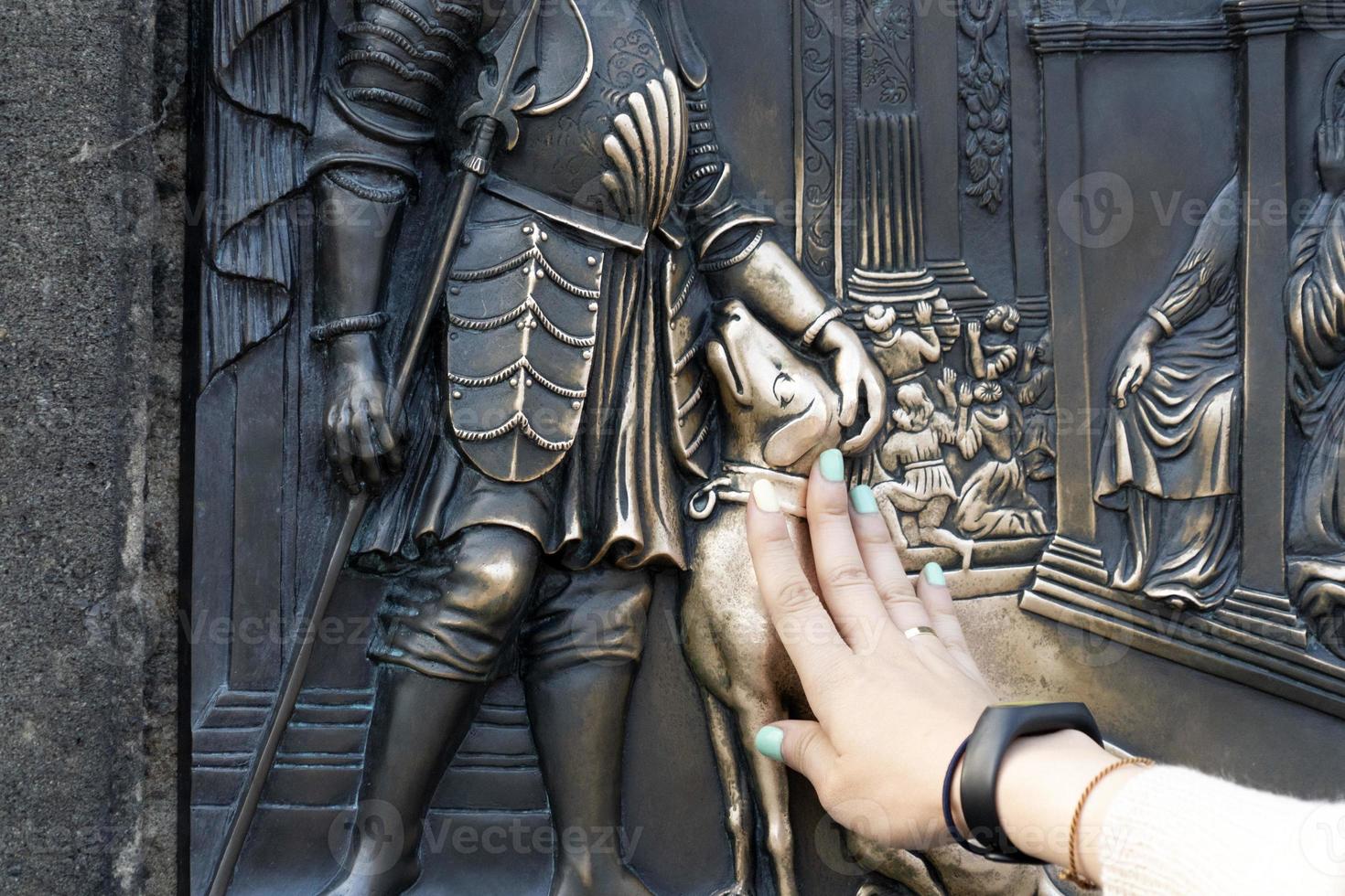 mãos tocando a estátua do cachorro na ponte charles praga foto