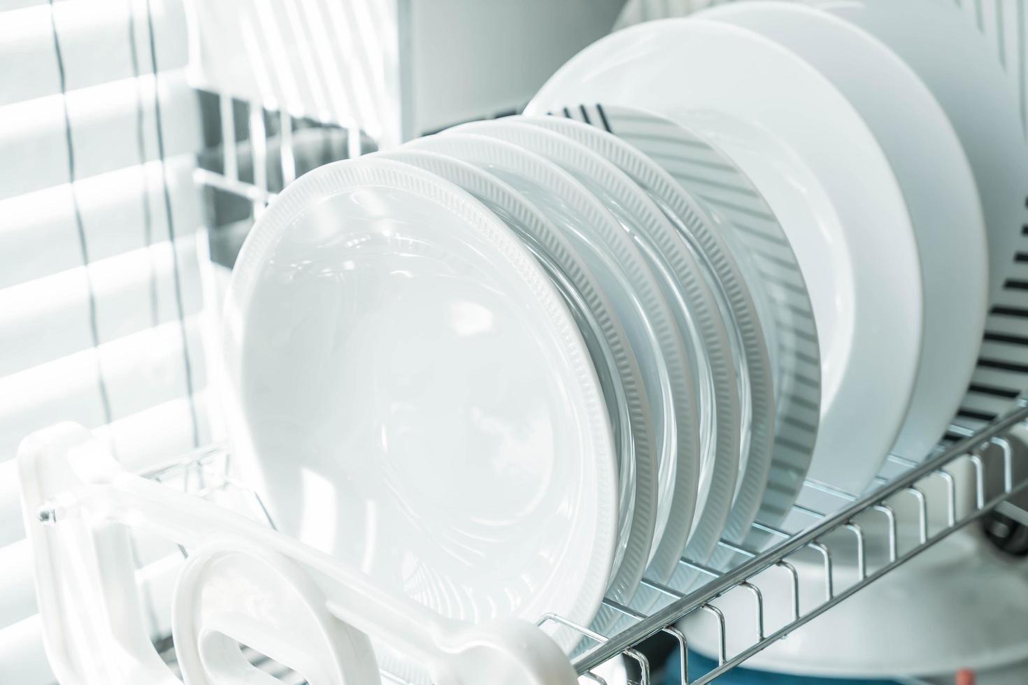 pratos limpos e brancos em um suporte para pratos foto