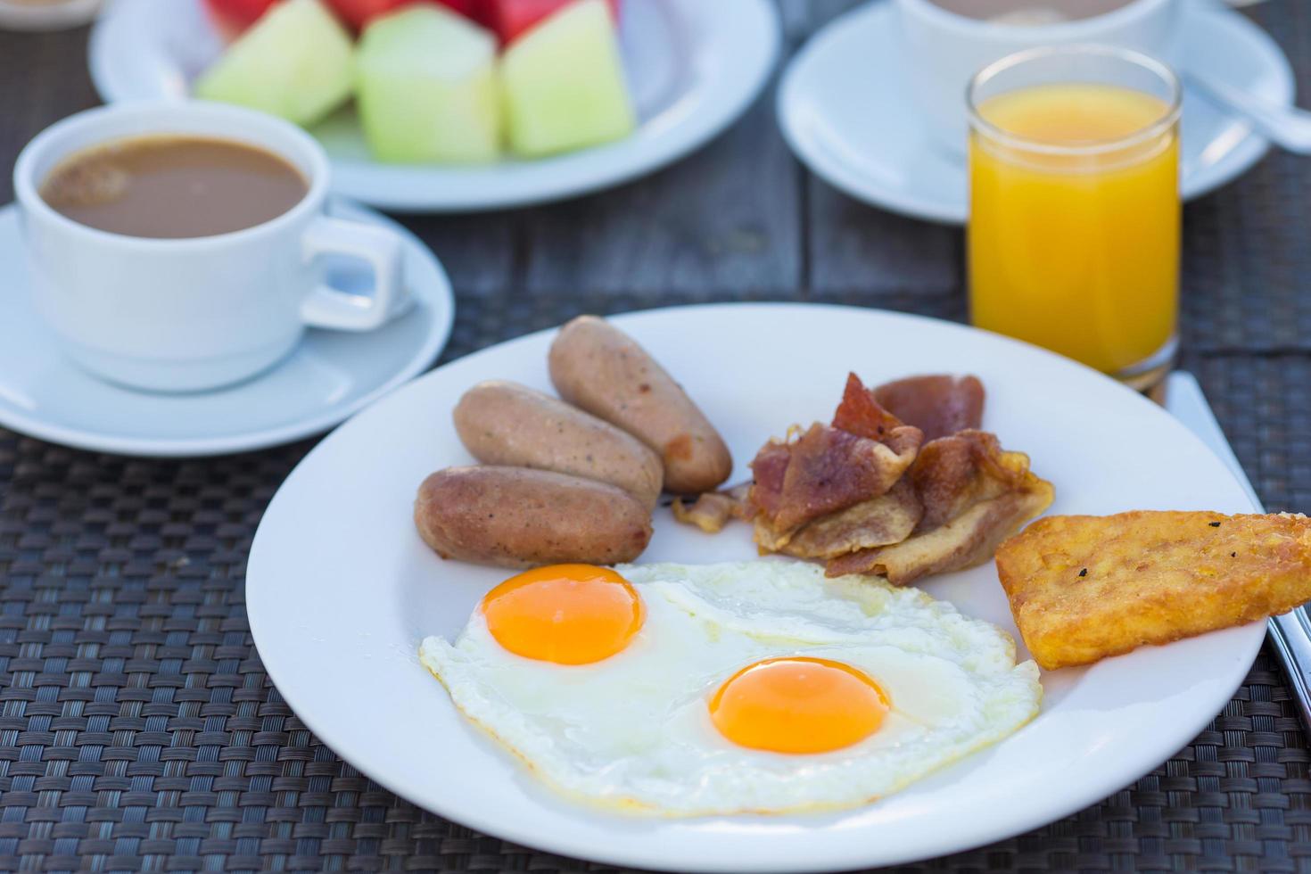 prato com ovos fritos, bacon e salsichas foto