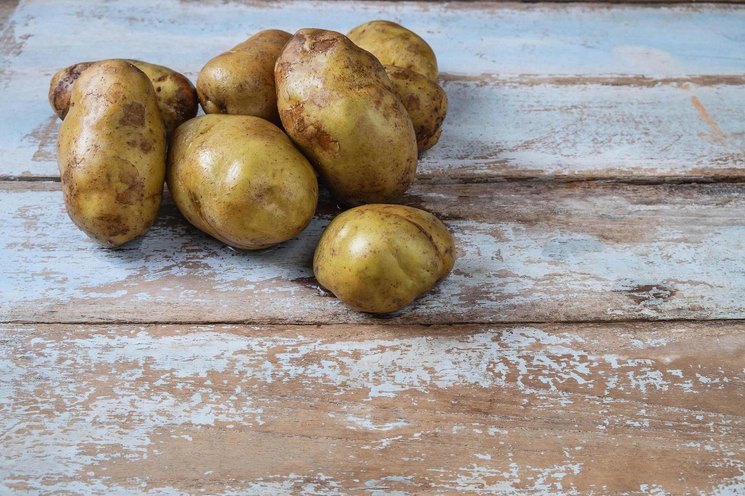 batatas em um fundo de madeira foto