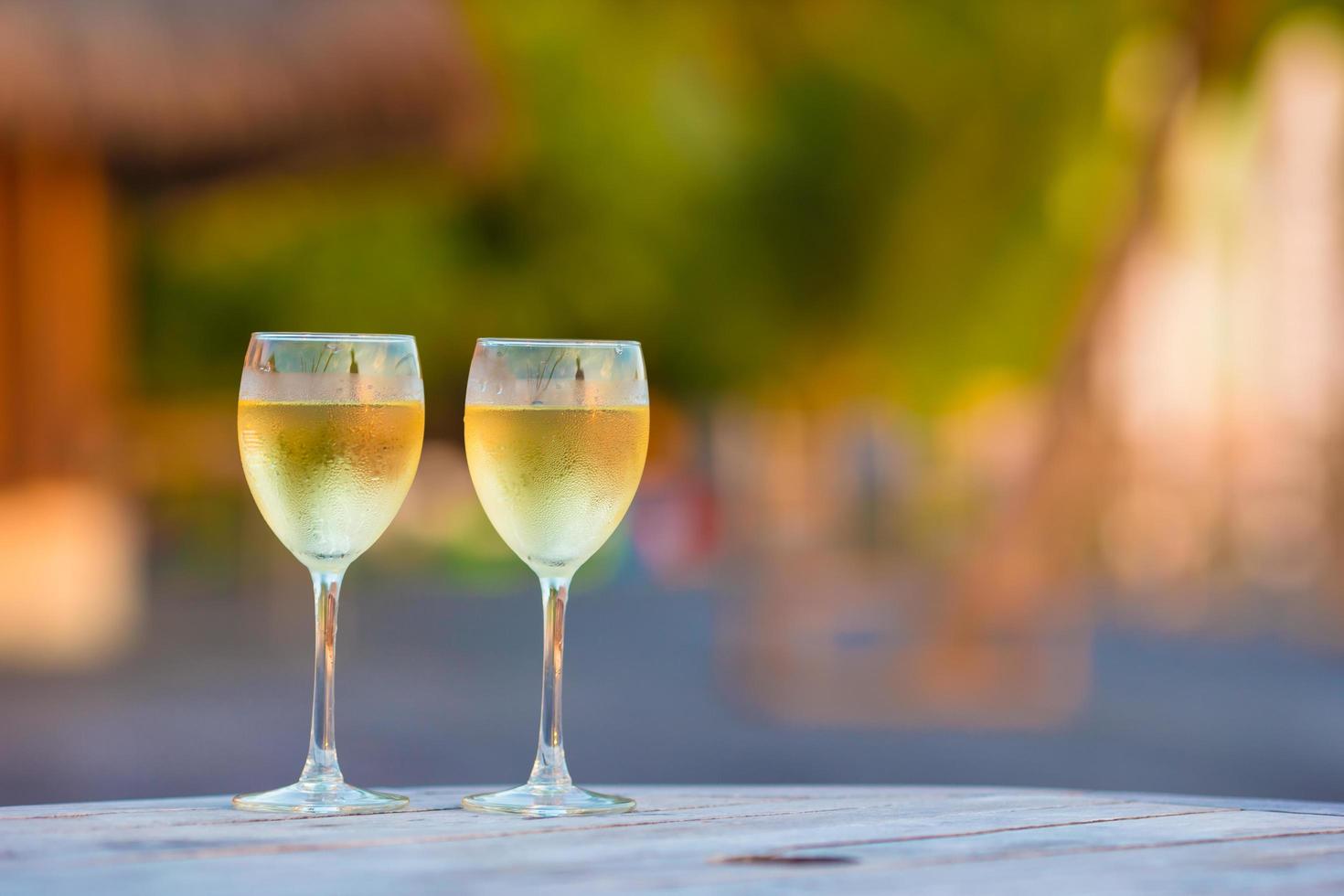 taças de vinho branco na hora do ouro foto