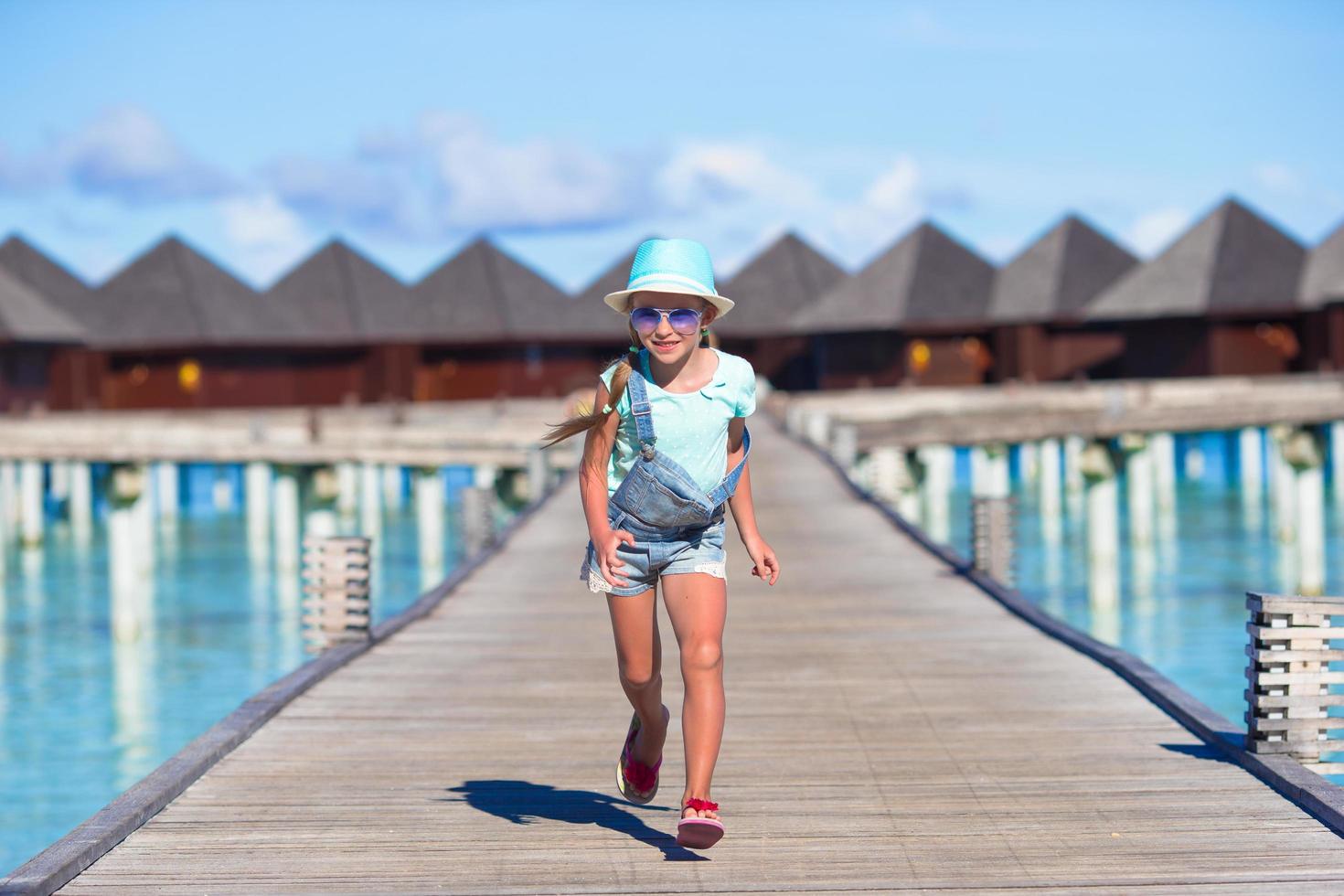 maldivas, sul da ásia, 2020 - garota correndo em uma doca em um resort foto