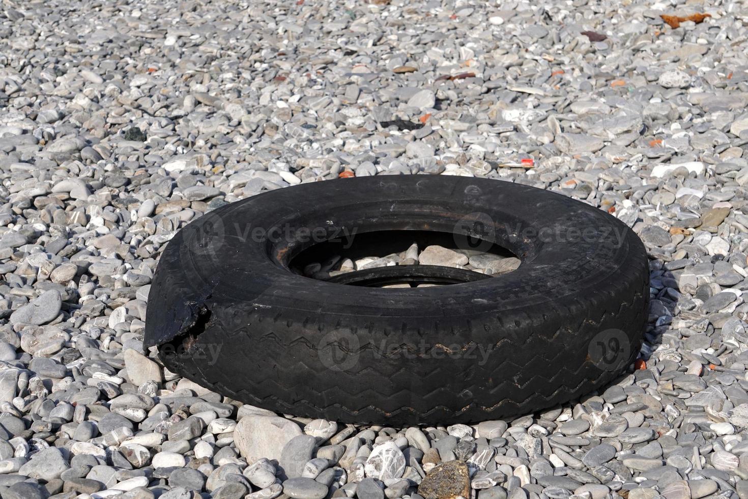 pneu abandonado na praia foto