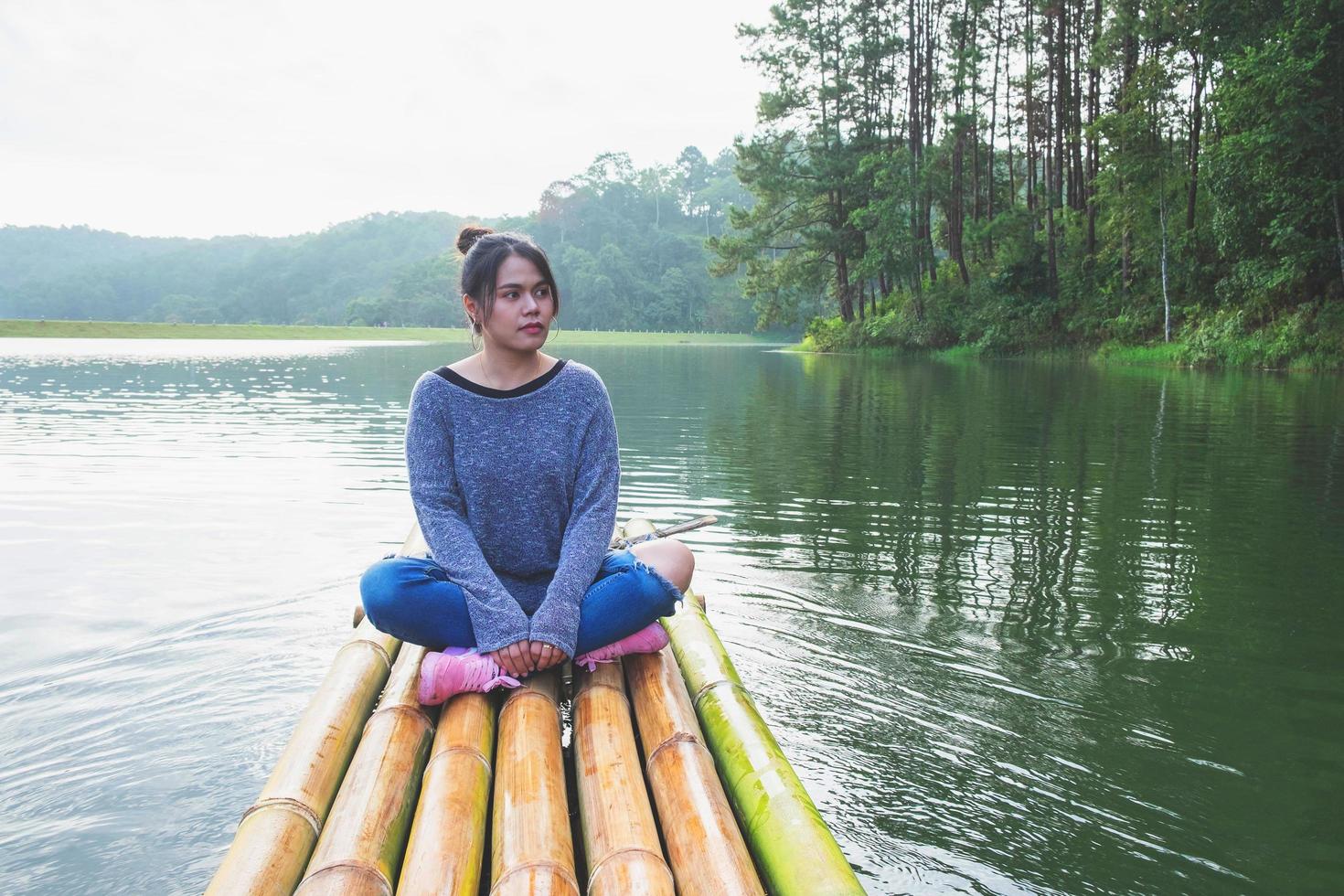 mulher sentada em um barco de bambu foto