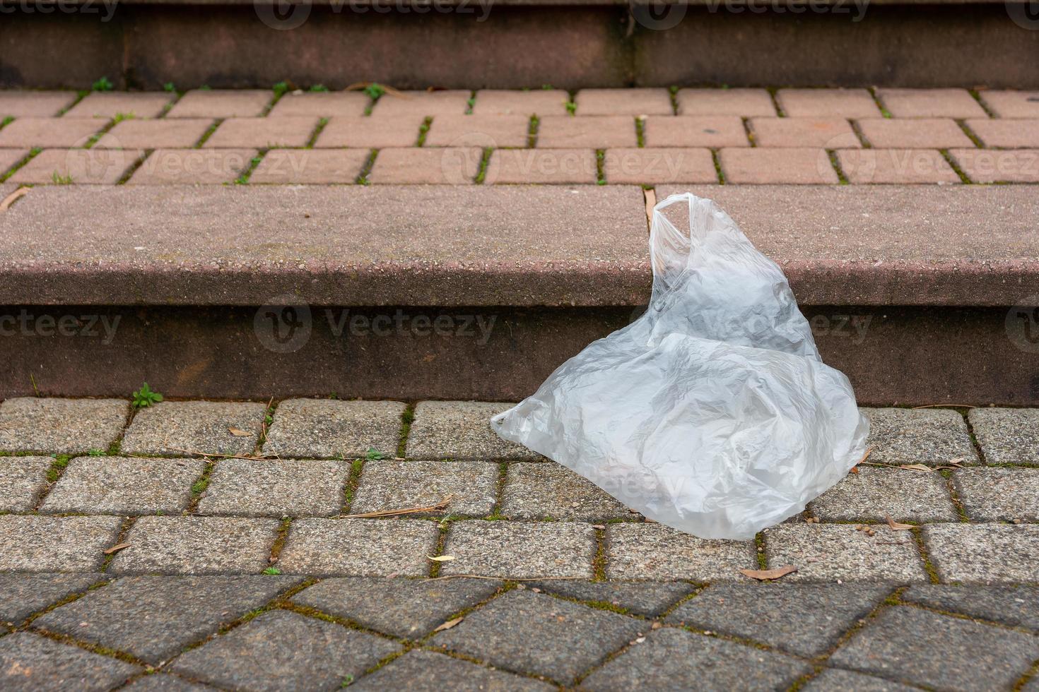 um saco de lixo plástico em uma rua foto