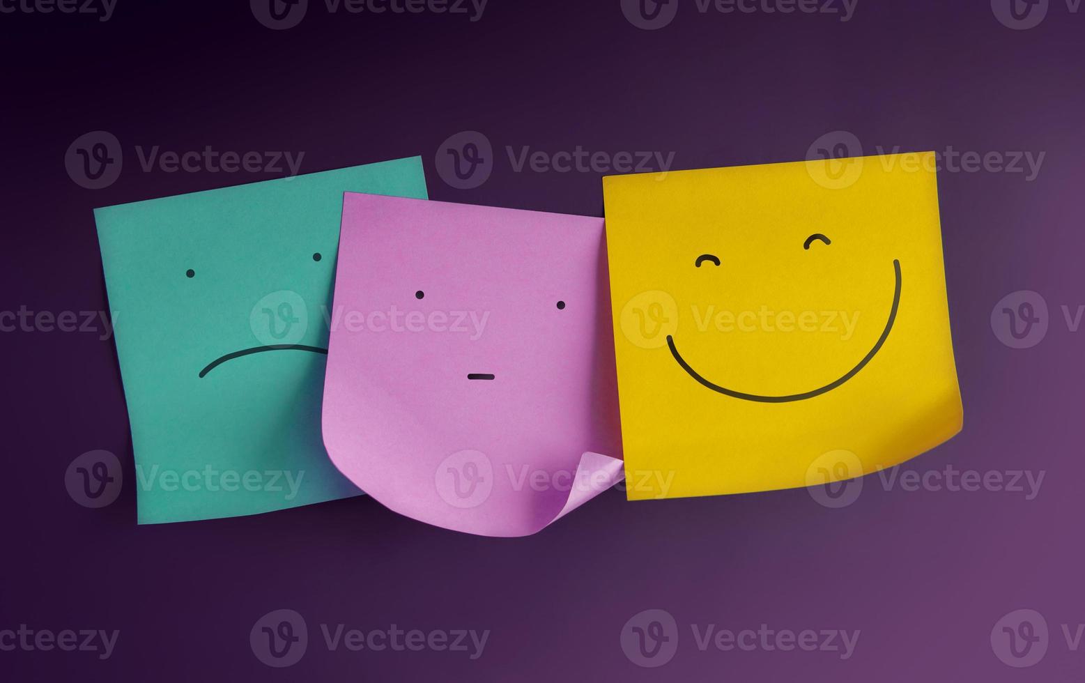 mente, conceito de saúde mental. três rostos de emoticons são exibidos em notas adesivas de negativo a positivo. entediado com o rosto sorridente. estado da emoção humana foto