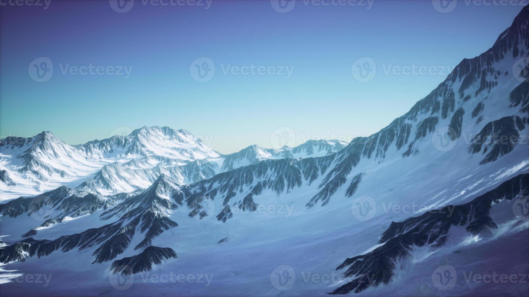 vista aérea do avião da paisagem montanhosa canadense coberta de neve azul foto