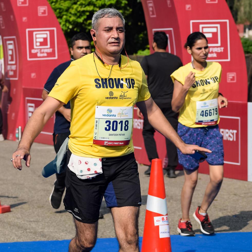 nova delhi, índia - 16 de outubro de 2022 - vedanta delhi meia maratona após covid em que os participantes da maratona prestes a cruzar a linha de chegada, meia maratona de delhi 2022 foto