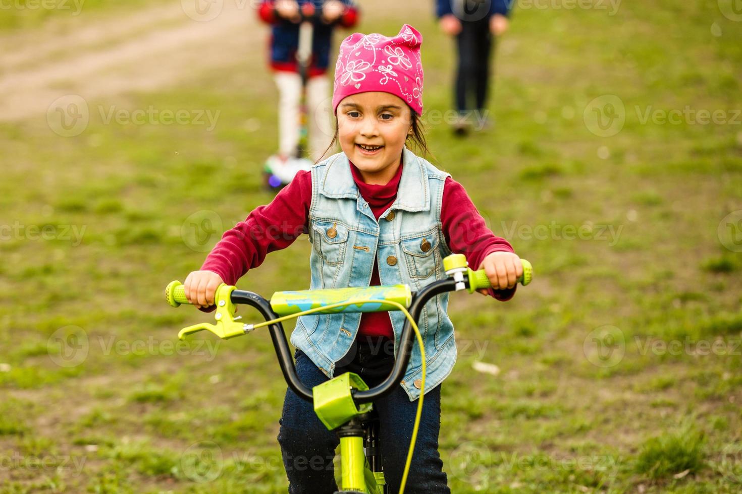 três crianças felizes andando de bicicleta foto