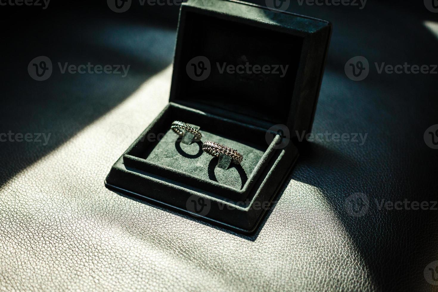elegantes anéis de casamento dourados em um fundo de caixa. anéis de luxo. espaço para texto foto