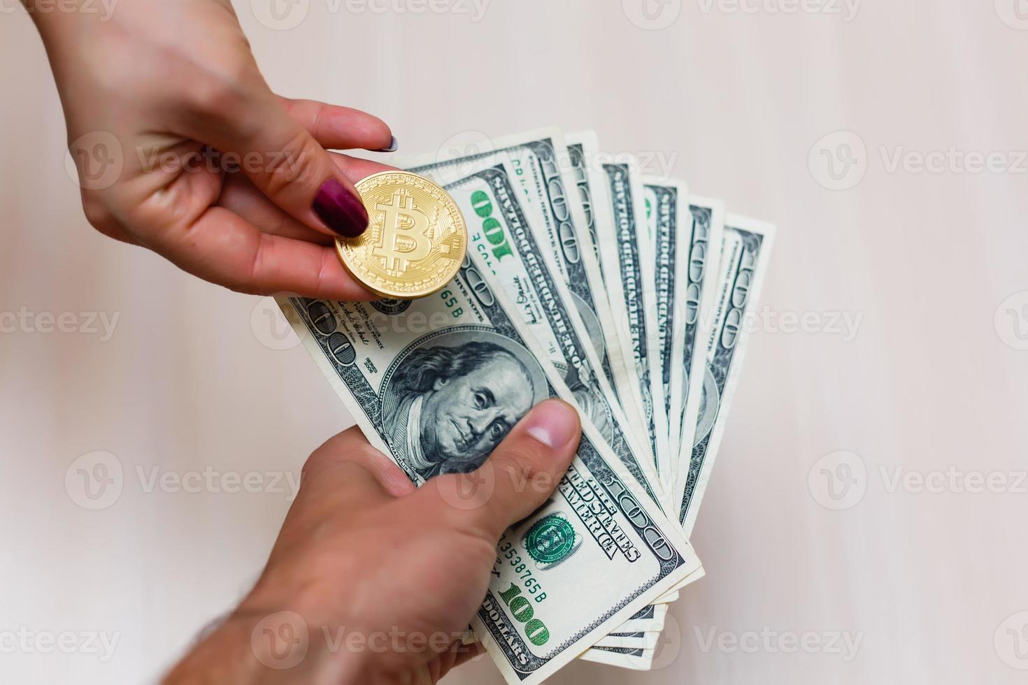 bitcoins dourados em dólares americanos nas mãos conceito de troca de dinheiro eletrônico foto
