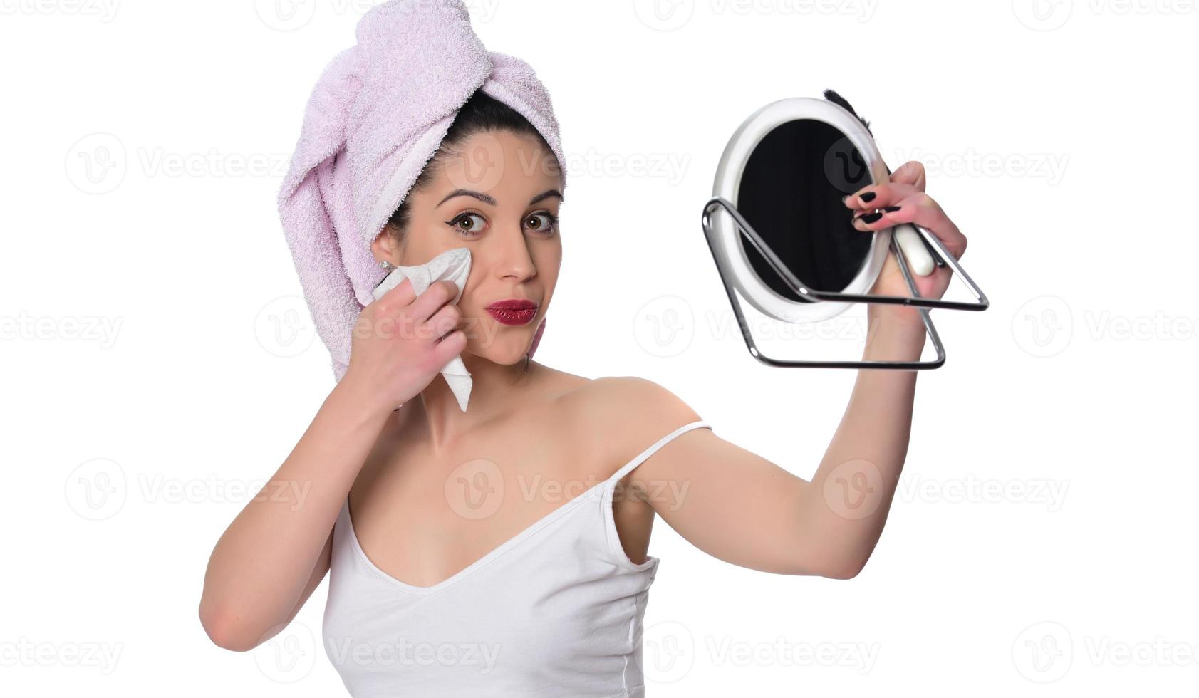 mulher limpando removendo a maquiagem do rosto com um guardanapo molhado foto