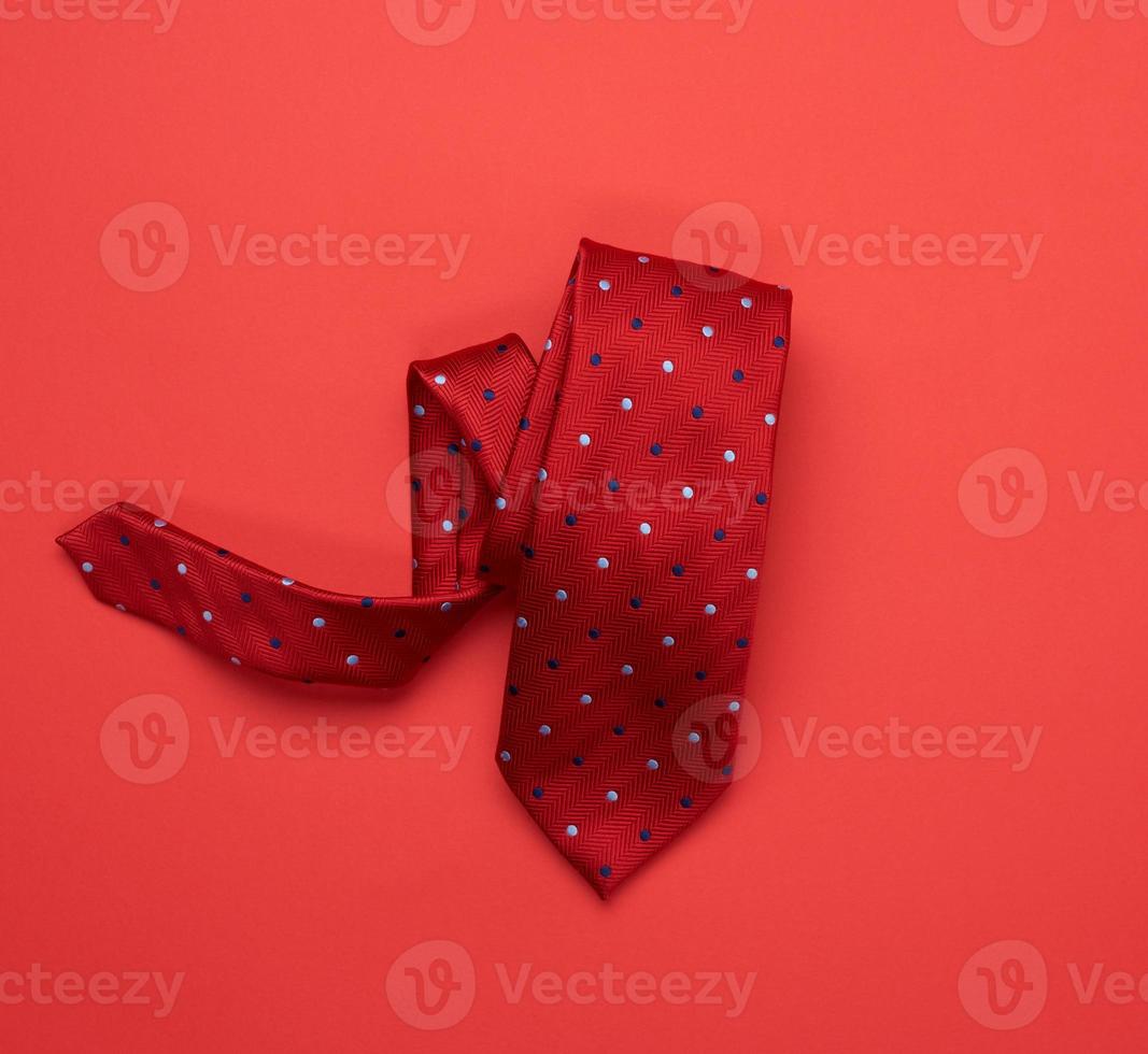 gravata vermelha de seda torcida em fundo vermelho foto