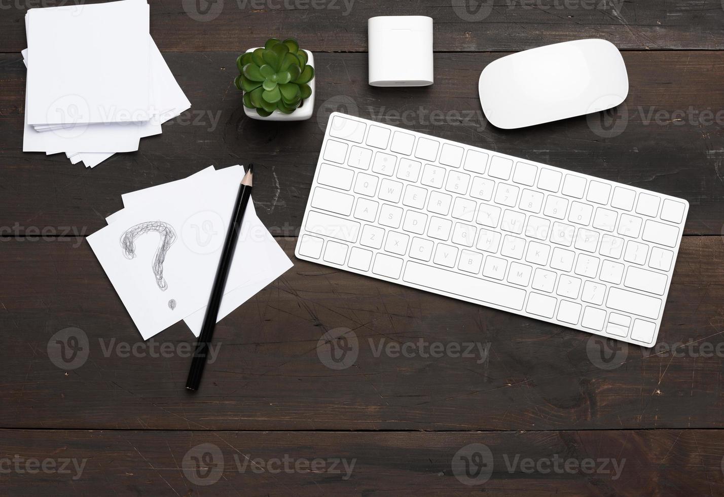 teclado sem fio branco e mouse em uma mesa de madeira marrom foto