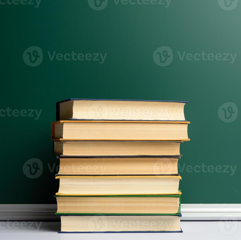 conselho escolar de giz verde em branco e pilha de livros, de volta à escola foto