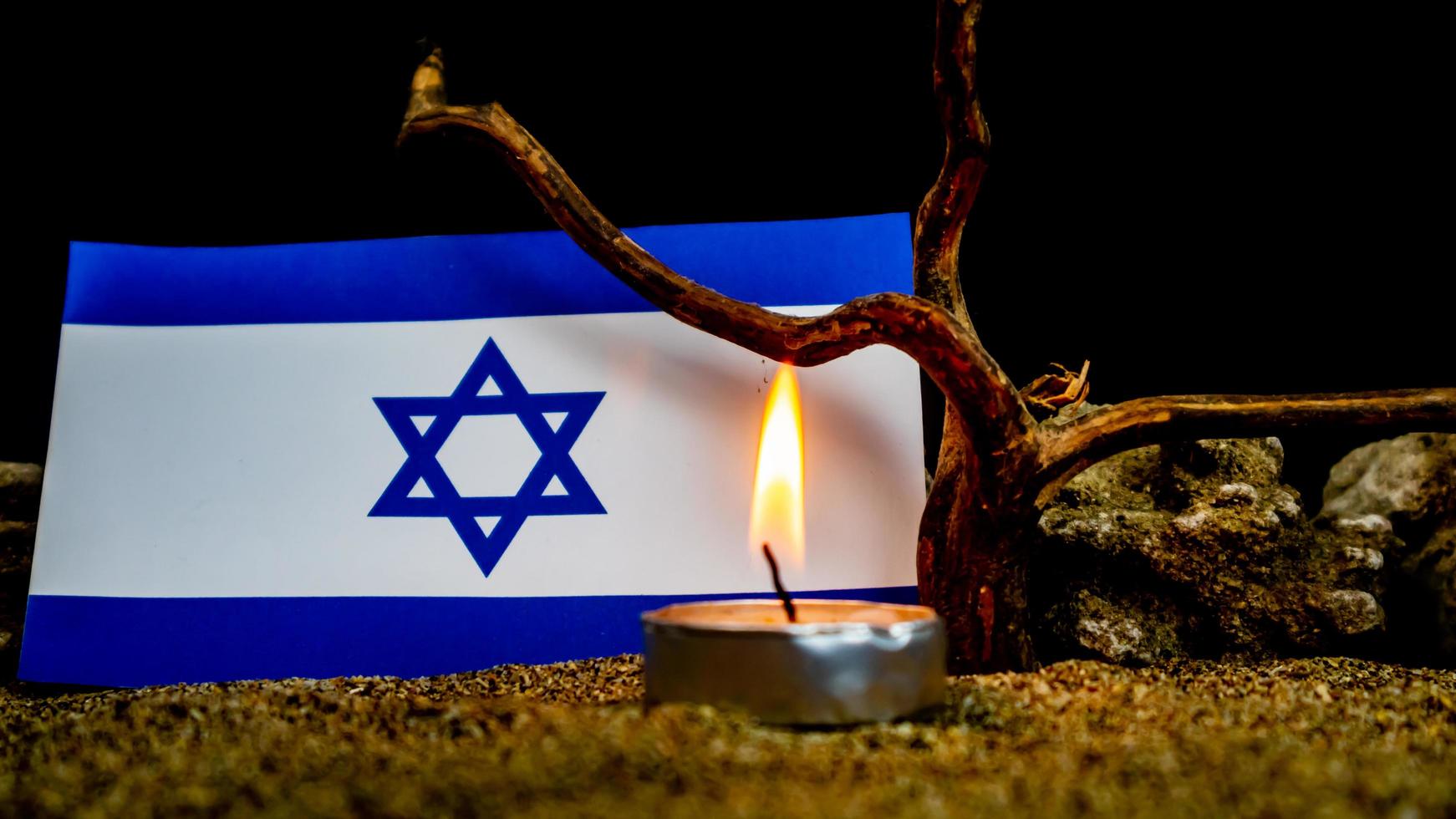 bandeira israelense e velas queimando na frente dela, dia da memória do holocausto foto