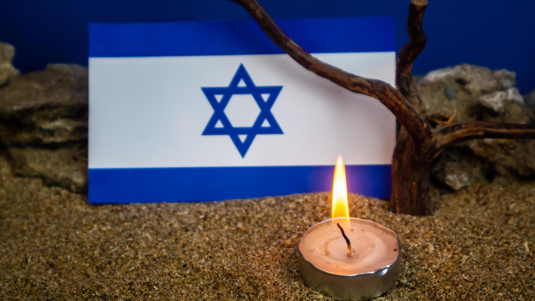 bandeira israelense e velas queimando na frente dela, dia da memória do holocausto foto