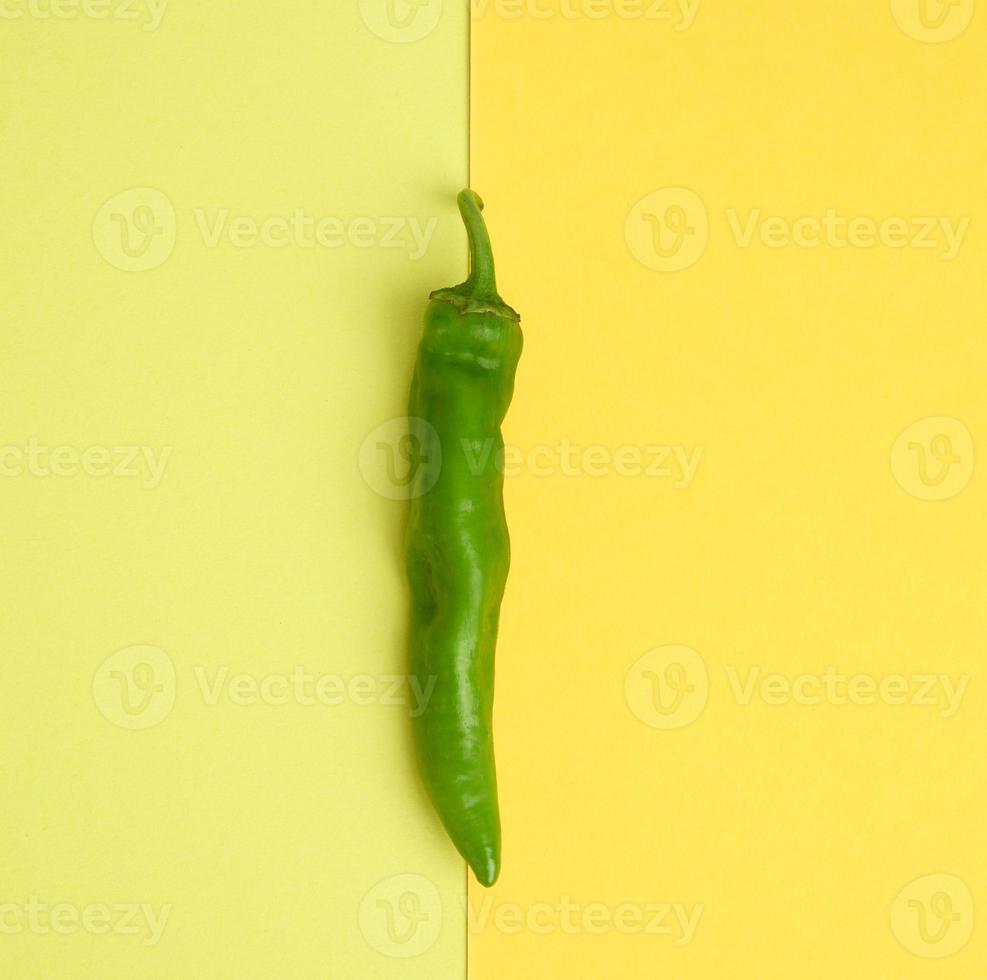 vagem de pimenta verde em um fundo amarelo foto