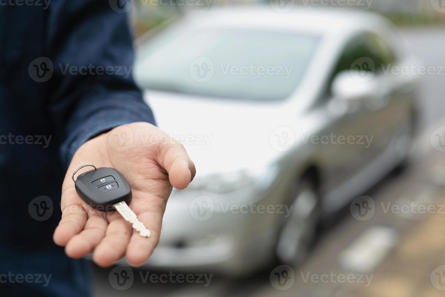 chave do carro, empresário entregando dá a chave do carro para o outro homem no fundo do carro. foto