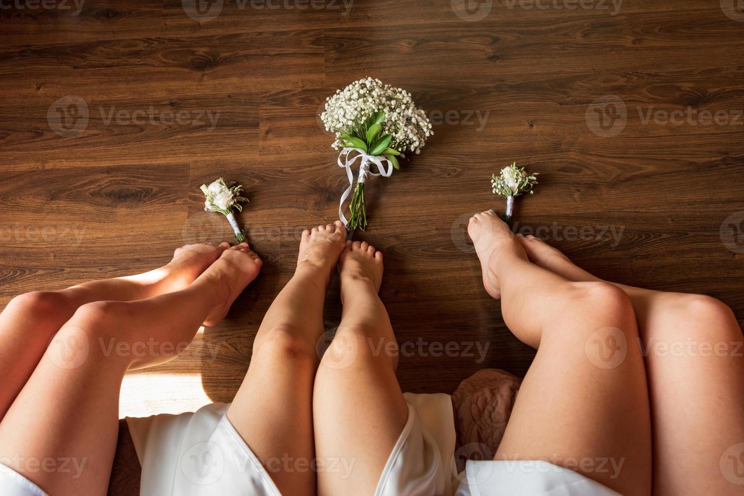 belas pernas delgadas da noiva e suas amigas. foto