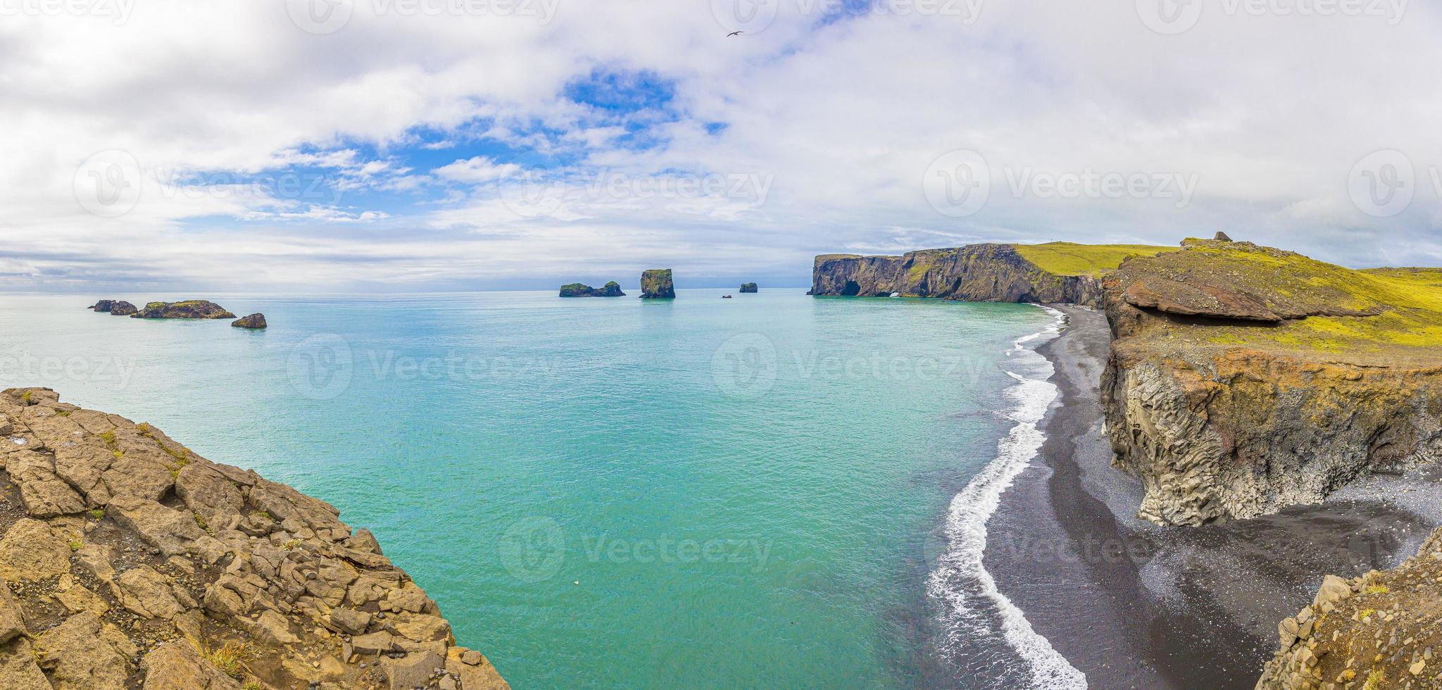 vista sobre arcos naturais na praia negra de reynisfjara, no sul da islândia foto