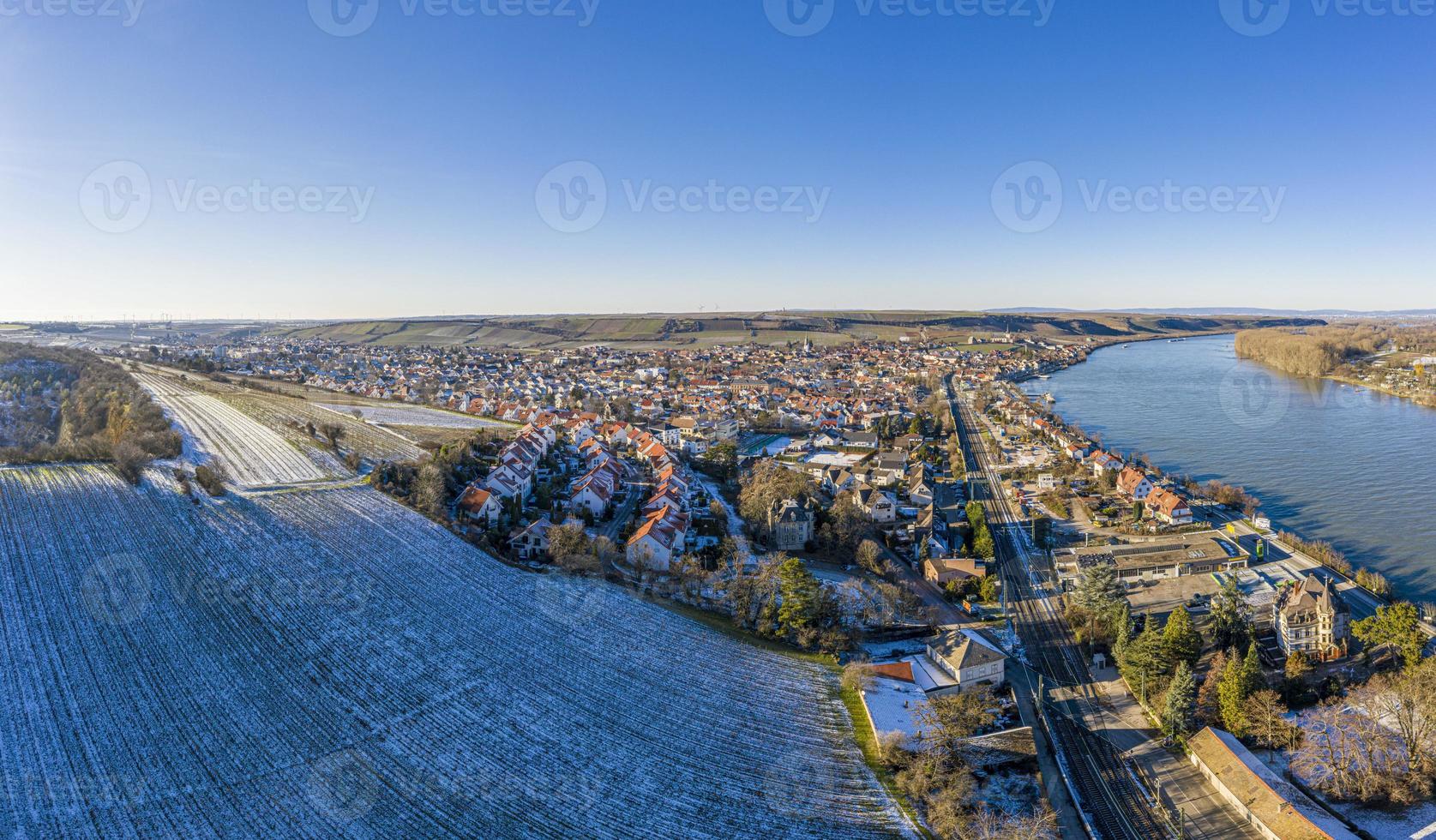 imagem de drone da vila de vinho nierstein no reno em céu azul e sol com encostas cobertas de neve foto