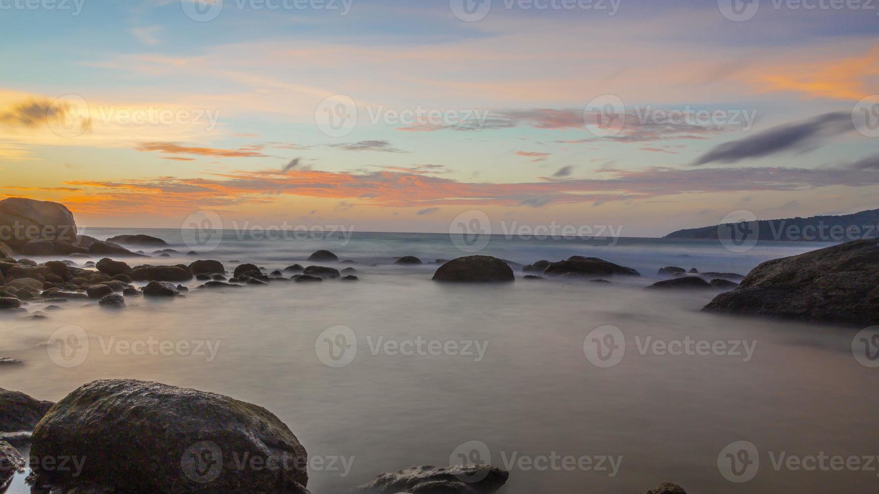 foto de longa exposição do pôr do sol colorido na praia de kamala, na tailândia, no verão