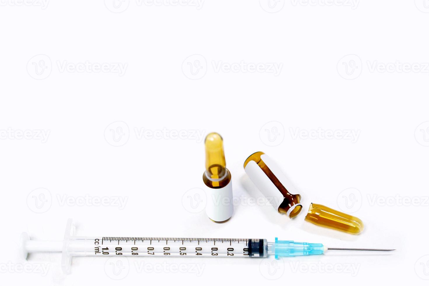 3 ml. ampolas marrons de droga são abertas e seringas de plástico com agulha médica em fundo branco. foto