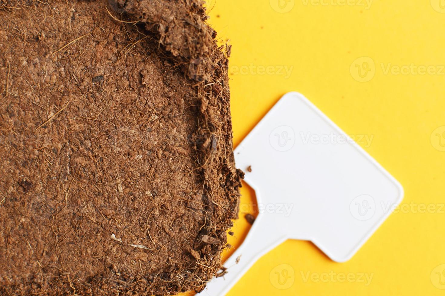 textura do solo de perto. brincar. briquete de coco com pranchetas em um fundo laranja. foto