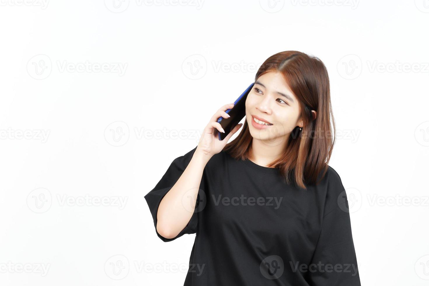 falando ao telefone e animado de linda mulher asiática isolada no fundo branco foto