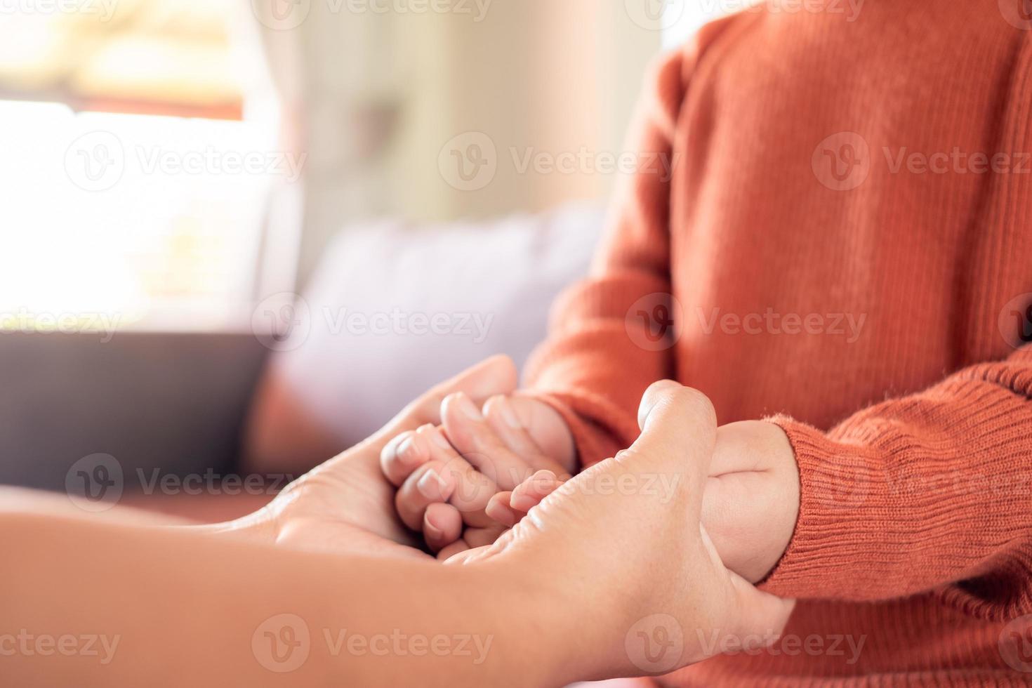 close-up da mãe segurando a mão do bebê em casa para encorajar e esperar, conceito de família feliz foto