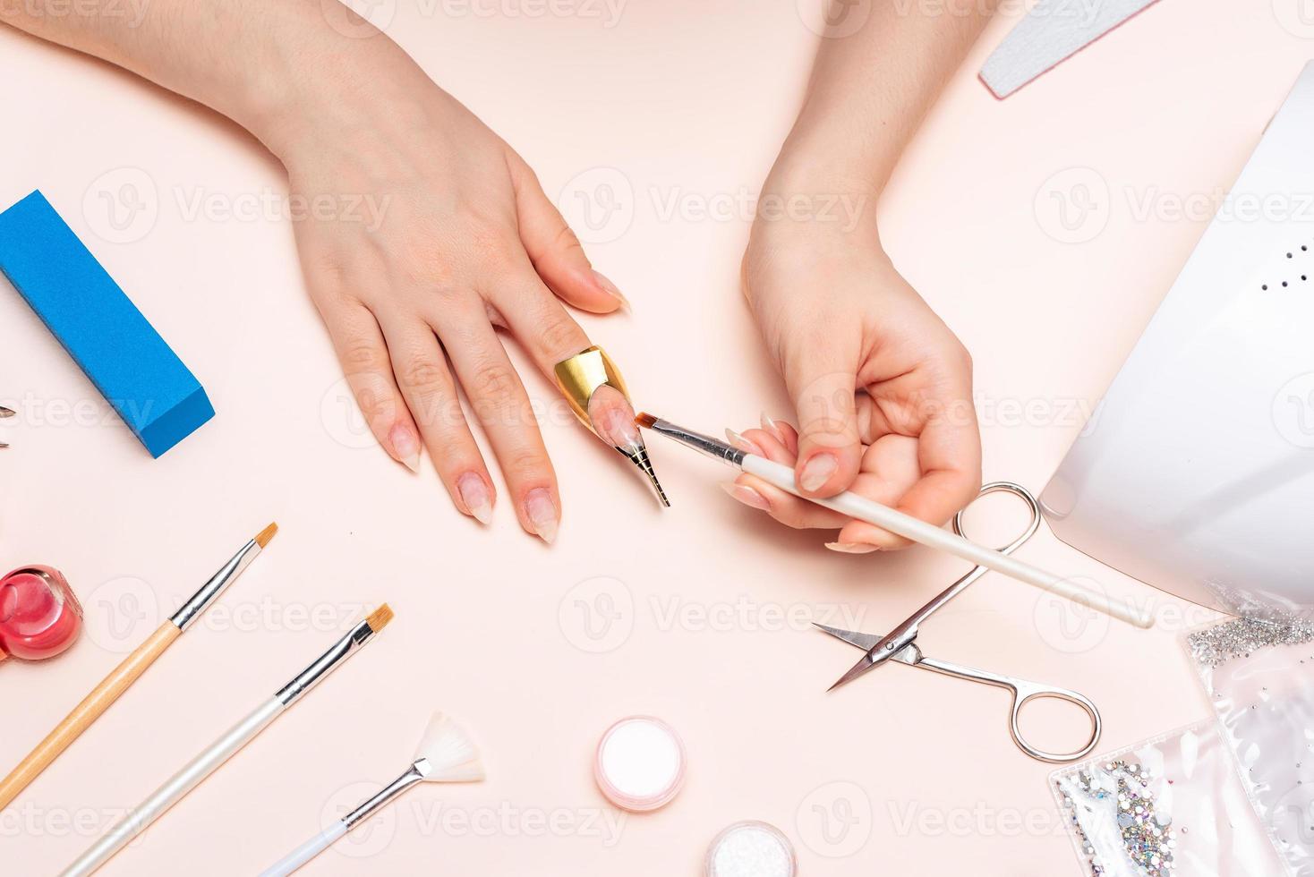 uma garota fazendo manicure em casa, close-up de mãos. A vista do topo foto