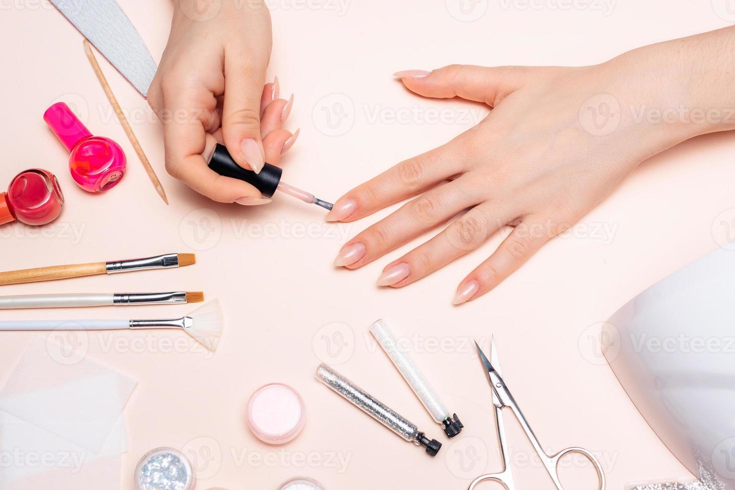manicure. uma garota pinta as unhas. mãos fecham foto
