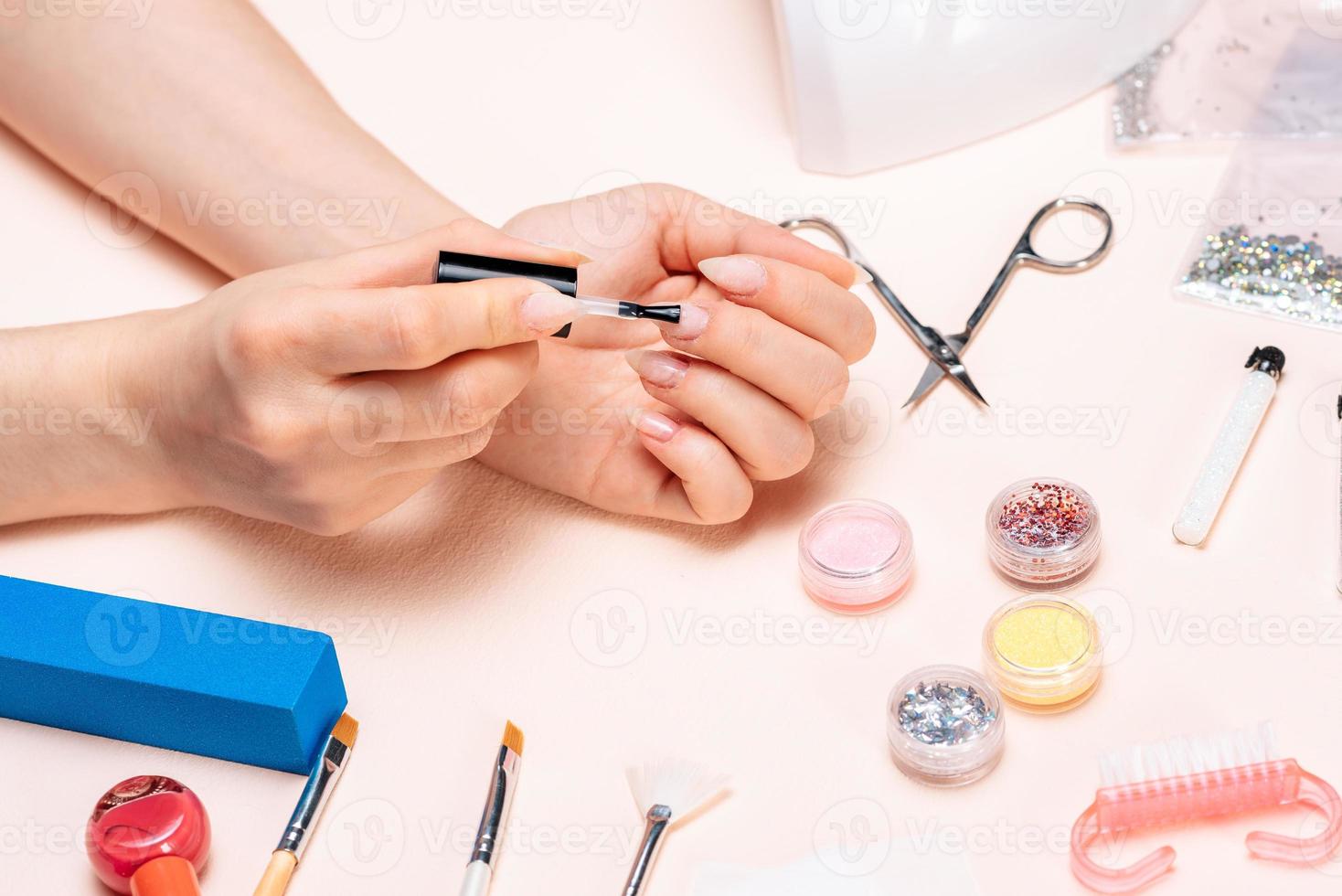 mãos de uma garota fazendo manicure em casa, close-up de mãos. A vista do topo foto
