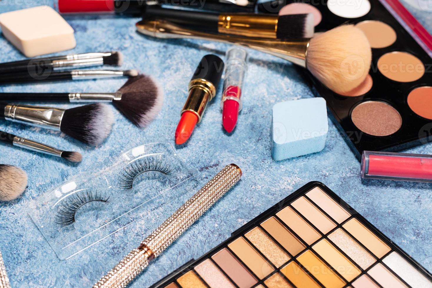 conjunto de cosméticos decorativos, pincéis de maquiagem em um fundo azul. A vista do topo foto