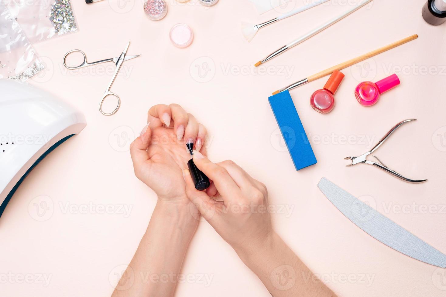 uma garota fazendo manicure em casa, close-up de mãos. A vista do topo foto