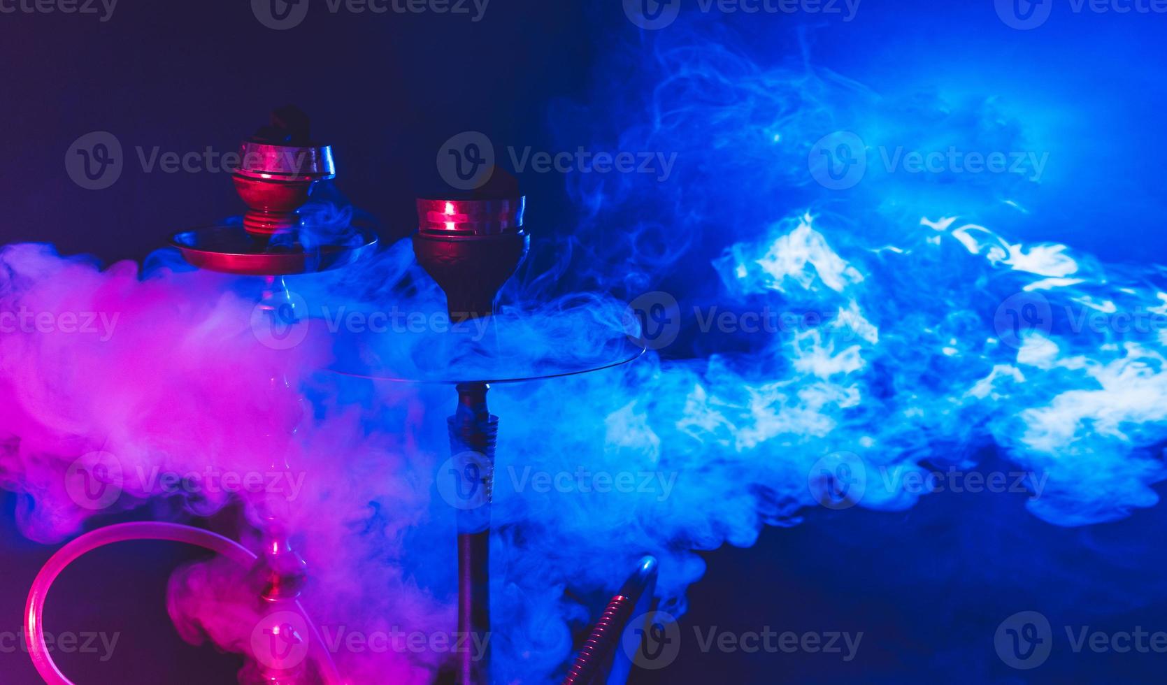 cachimbo de água moderno, shisha em um fundo preto esfumaçado com iluminação colorida e fumaça. close-up e lugar para o seu texto foto