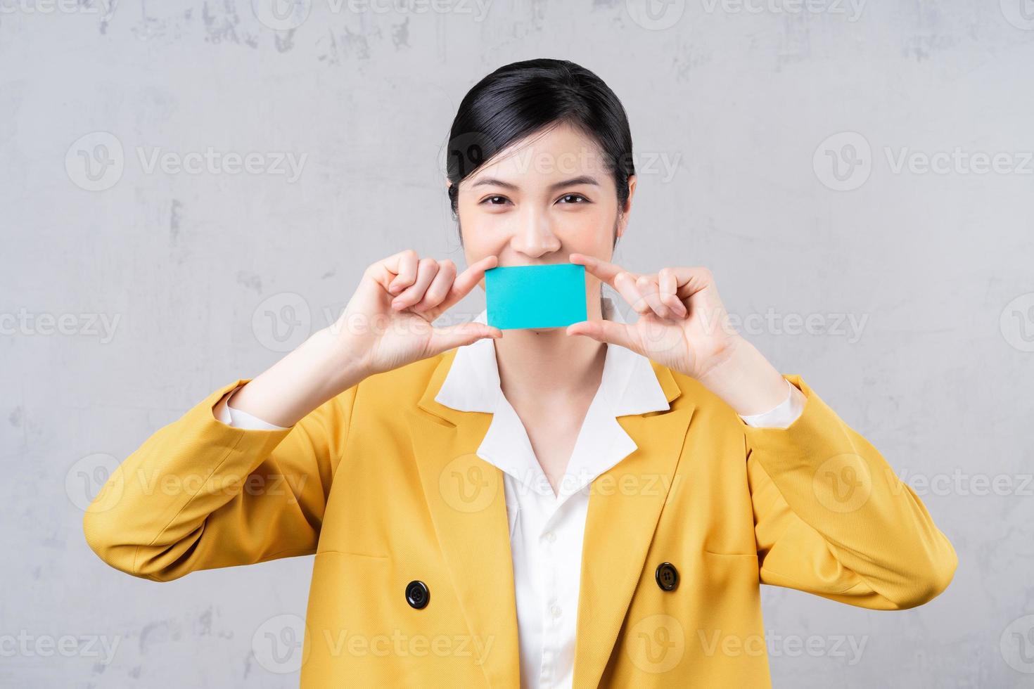 imagem de uma jovem mulher asiática segurando o cartão do banco foto