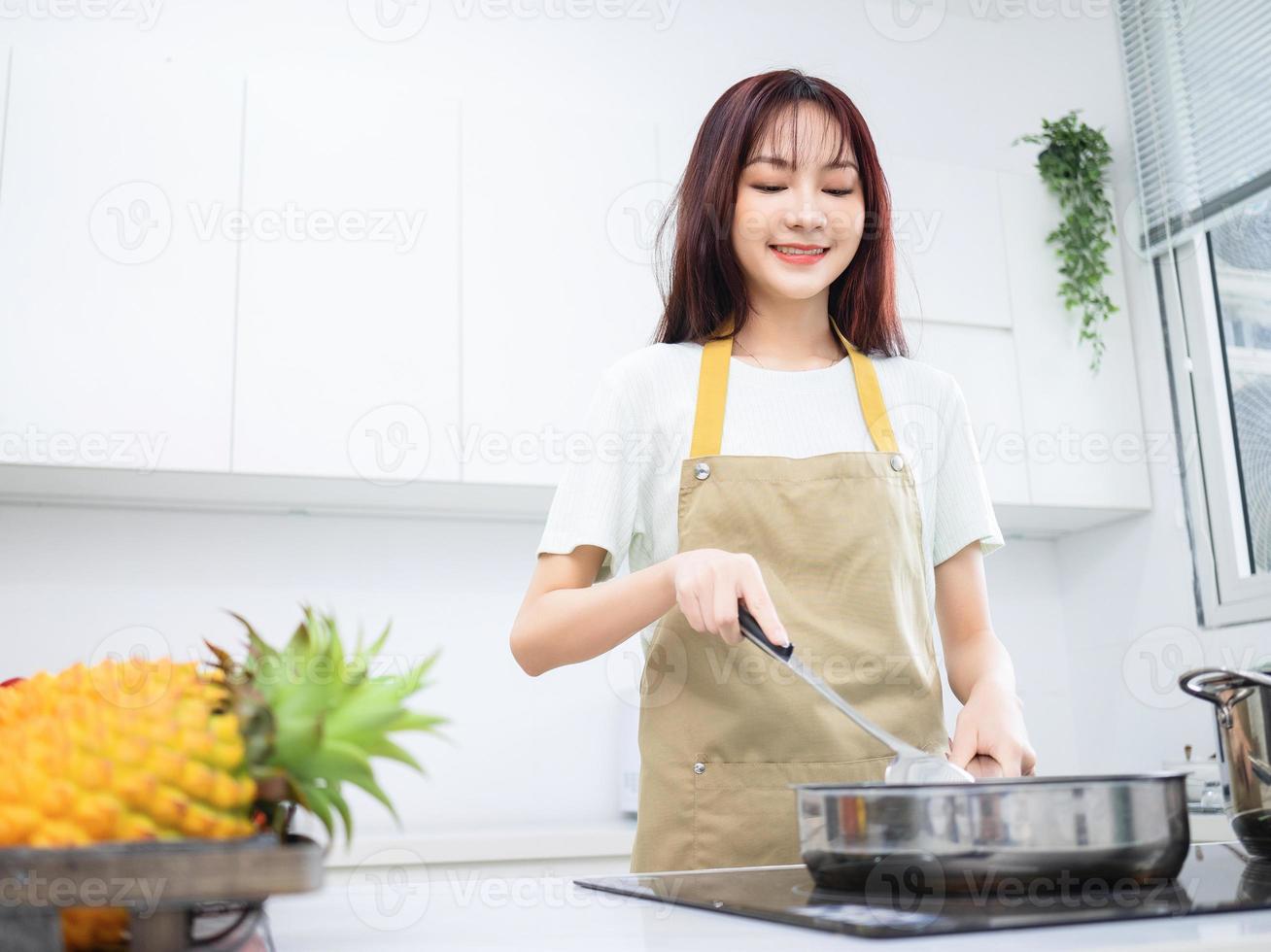 imagem de jovem asiática na cozinha foto