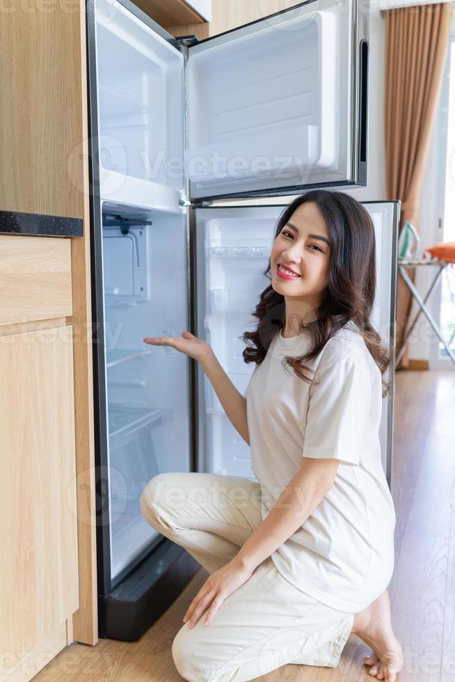 imagem de jovem asiática com geladeira foto