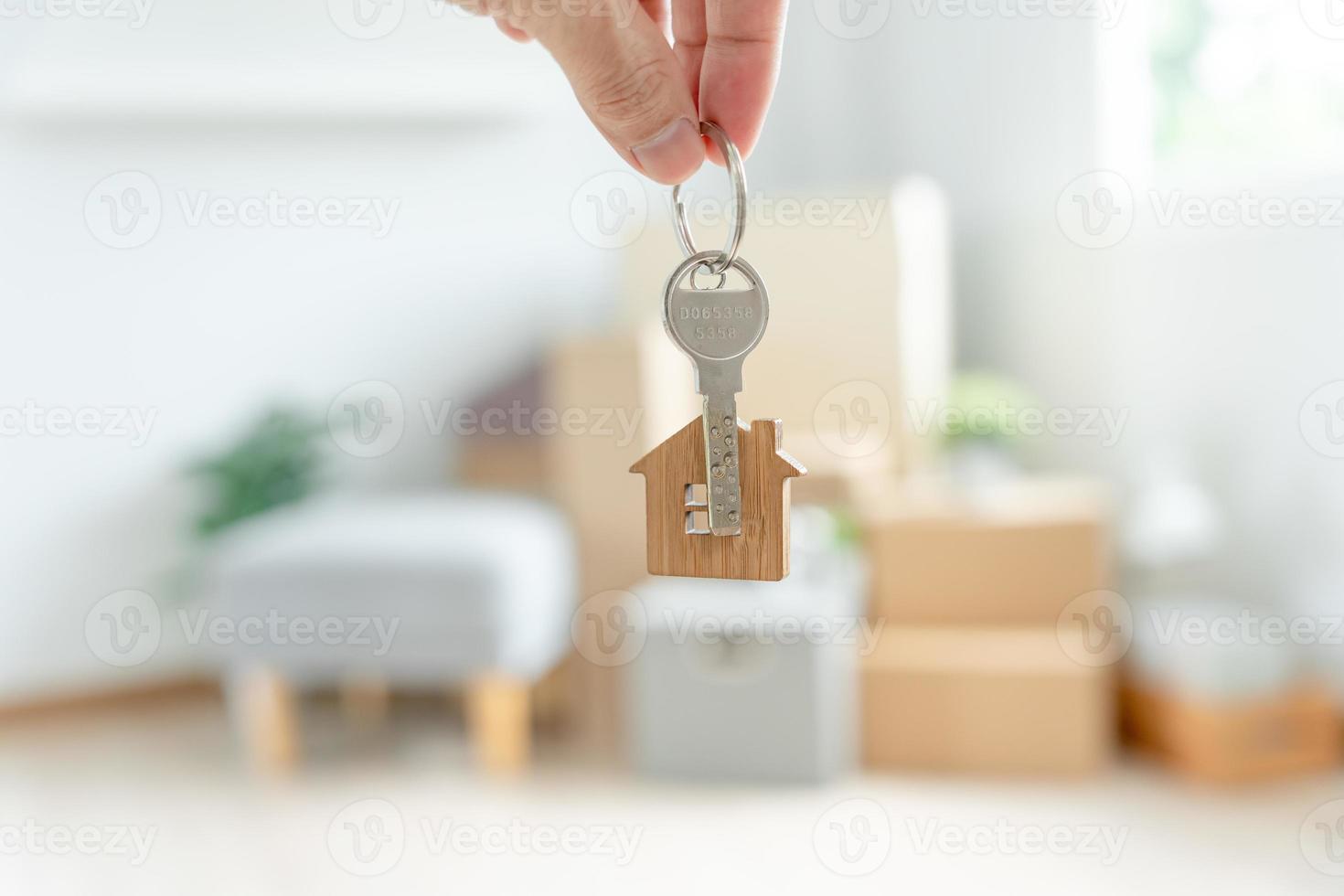 mudança de casa, realocação. mulher segura o chaveiro chave da casa no novo apartamento. mover em casa nova. comprar ou alugar imóveis. arrendamento plano, propriedade arrendada, novo senhorio, habitação, empréstimo, hipoteca. foto