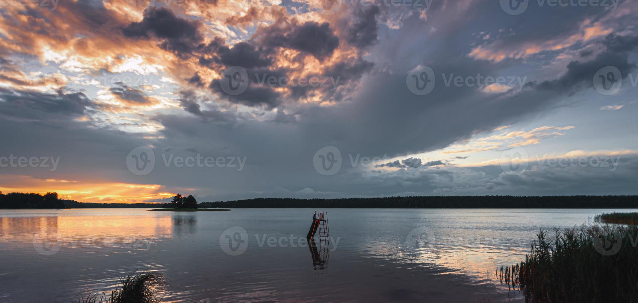 grama e lago durante o pôr do sol foto