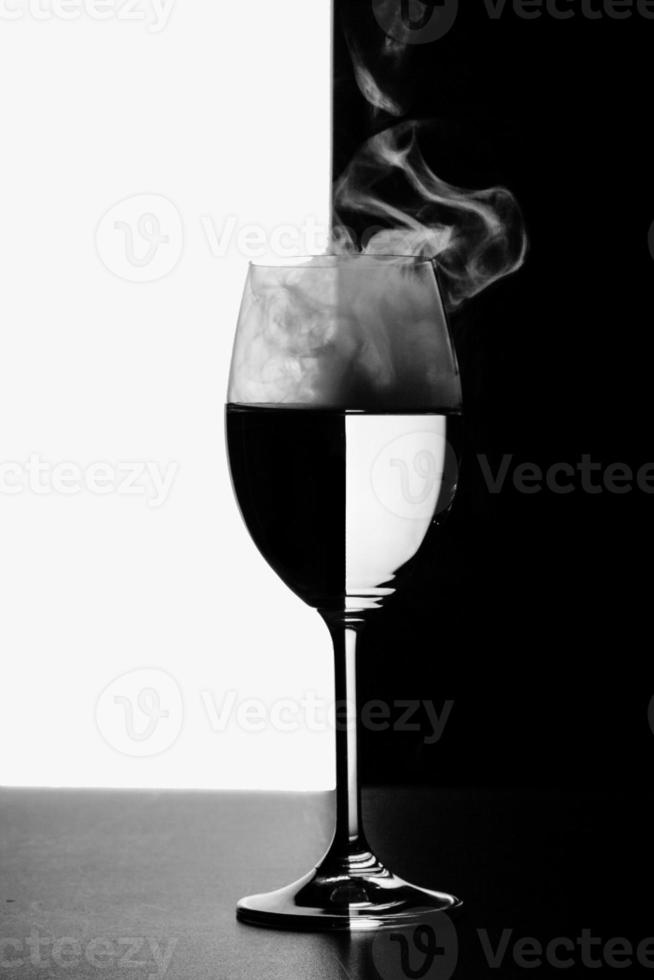 um copo de água e fumaça em um fundo preto e branco foto